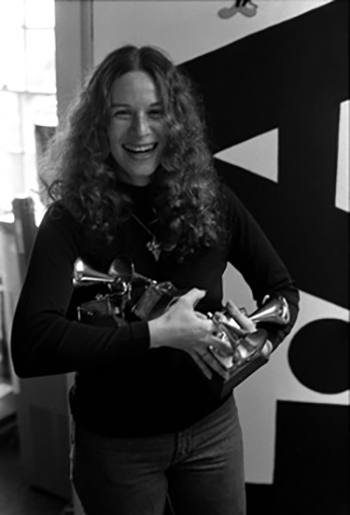 Carole King holding her Grammy awards